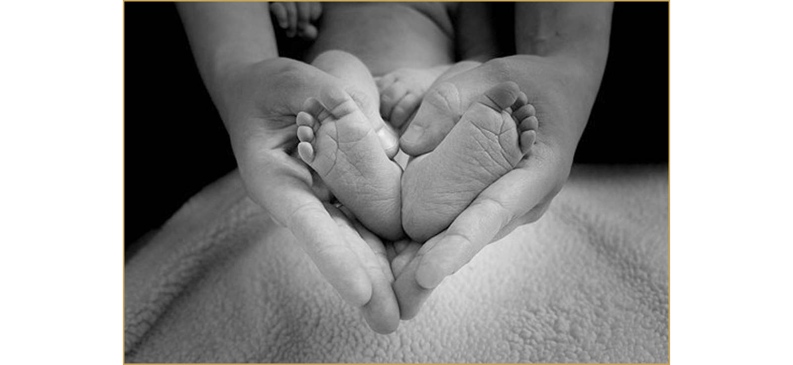 Erwachsenen-Hände und Baby-Füße verschlungen zu einer Herzform.